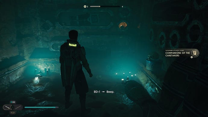 Star Wars Jedi: Survivor screenshot showing Cal stood in a dark room, lit by a dim turquoise glow.