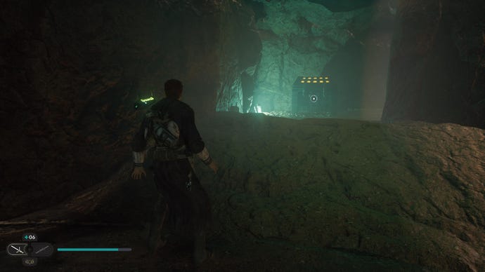 Star Wars Jedi Survivor screenshot showing Cal Kestis in a dark building, looking up at a rocky ledge that's illuminated with green light.