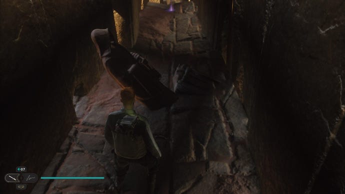 Star Wars Jedi Survivor screenshot showing Cal stood near a collapsed statue in a dark corridor.