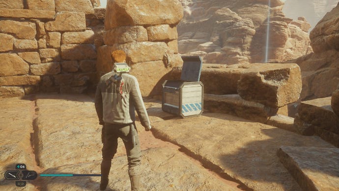 Star Wars Jedi Survivor screenshot showing Cal stood near a chest on a sandy ledge.
