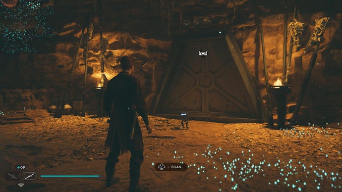 Star Wars Jedi Survivor screenshot showing Cal stood in a warmly lit cave network near a sealed blast door.