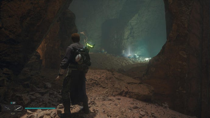 Star Wars Jedi: Survivor screenshot showing Cal stood in a dark desert cave.