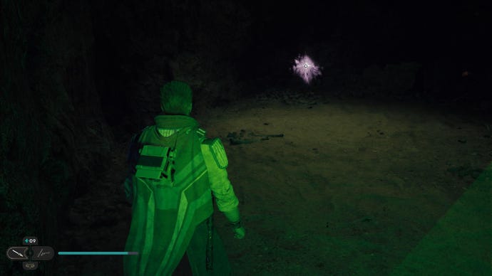 Star Wars Jedi: Survivor screenshot showing Cal stood in a dark cave, lit by a bright green glow.