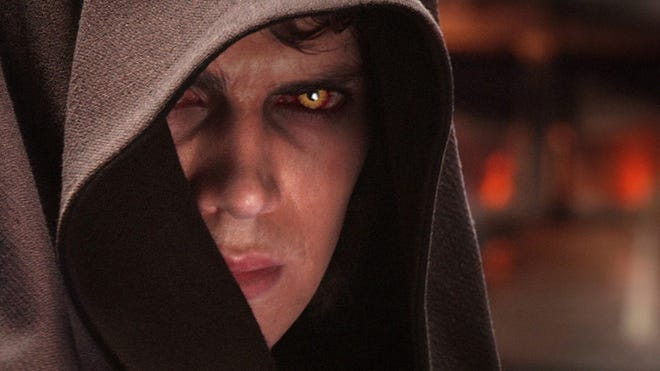 Star Wars Revenge of the Sith Hayden Christensen as a corrupt Anakin Skywalker, his eyes glowing orange and red while wearing a Jedi hood