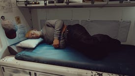 A blonde man asleep on a space bed in Starfield