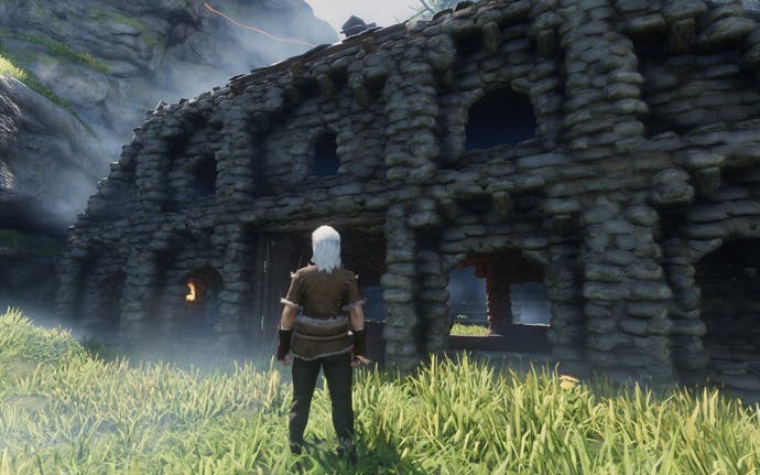 Enshrouded screenshot showing A woman stands in front of a stone building, which has elaborate arches over its window frames, made possible by Enshrouded's building system.