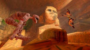 Lara Croft aims both pistols while jumping in the air facing off against a mummified dog (or other animal, it's hard to tell). A sphinx with a partially broken face is in the background.