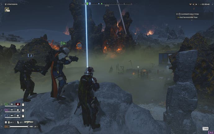 اسکرین شات Helldivers 2 که سه غواص جهنمی را نشان می دهد که از بالا به یک مرکز متروکه پر از اشکالات، در یک سیاره سبز تیره با آتش سوزی در پس زمینه نگاه می کنند.