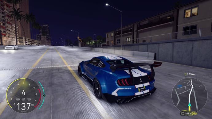 The Crew Motorfest screenshot, showing a Shelby Cobra with an enormous spoiler, cruising at night.