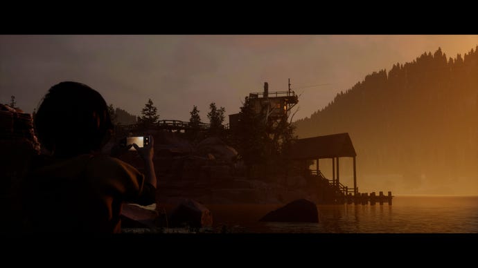 Kaitlyn, one of the player characters in The Quarry, uses her phone to take a photo of the camp lake at sunset