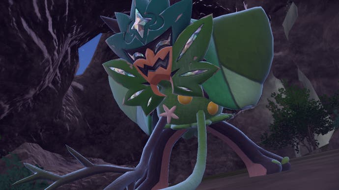 Pokémon The Teal Mask screenshot showing the DLC's legendary Pokémon with a green mask on in a cave