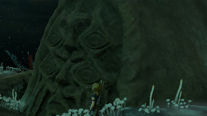 Link standing by a Bargainer statue in The Legend of Zelda: Tears of the Kingdom.