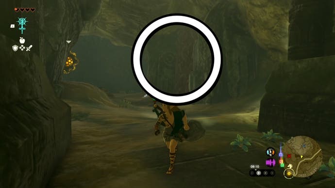 Link near a wall in the Tanagar Canyon West Cave which has been highlighted, which players need to destroy to find the Iun-orok Shrine.