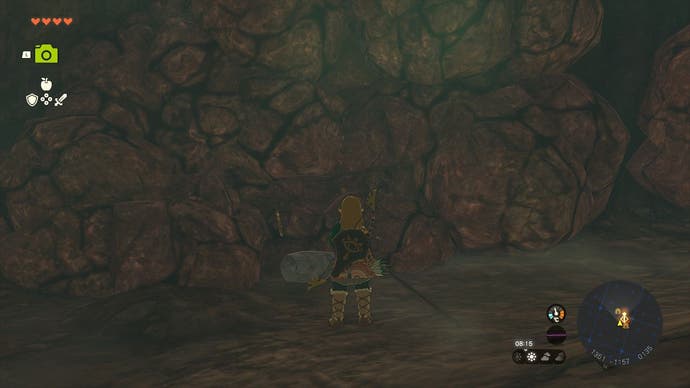 Link parado ao lado de rochas quebráveis que revestem as paredes da caverna de Sahasra Slope