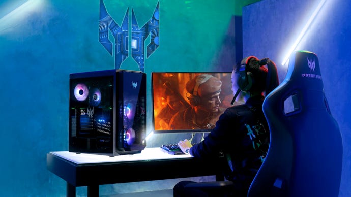The Acer Predator Orion 5000 sits on a desk, next to a woman playing games on it.