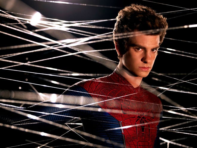 Andrew Garfield as Spider-Man without his cowl surrounded by webs.
