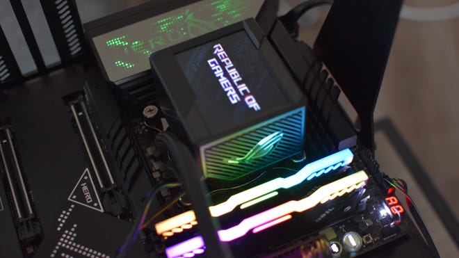 An Asus ROG Ryujin II 360 cooler pump, with its built-in display showing a ROG logo.