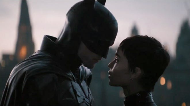 Batman and Catwoman lean close