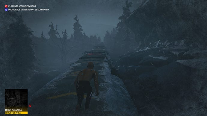 Agent 47 creeping on the top of a moving train in Hitman 3