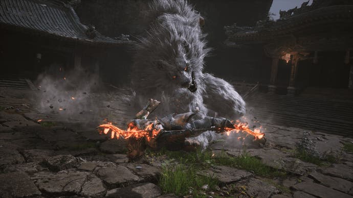 Captura de pantalla de Black Myth Wukong que muestra al personaje atacando a un gran lobo enemigo con un ataque de salto giratorio y llameante.