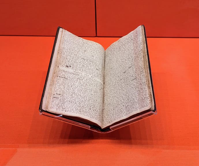 A small book with many lines of tiny, neat handwriting in it. It belonged to Charlotte Brontë and it contains her Glass Town: The Search after Happiness story.