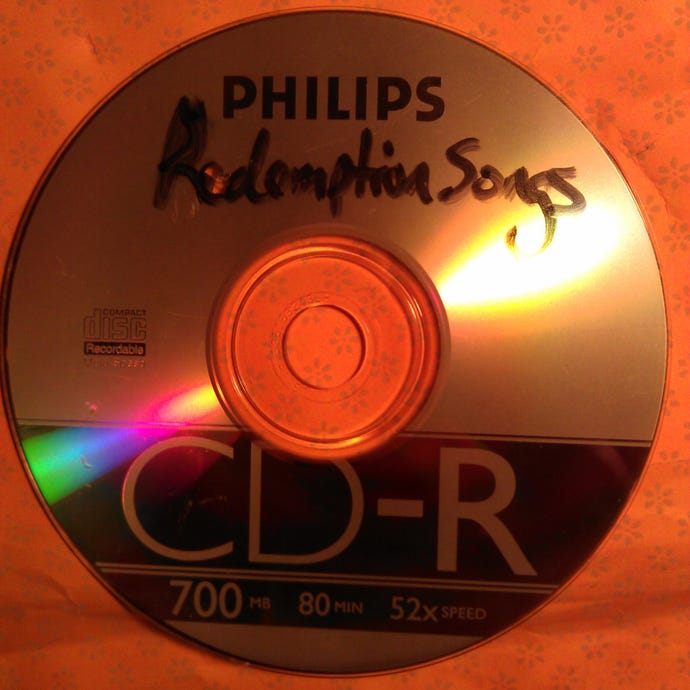 A photograph of a CD-R with the handwritten label 'Redemption Songs'.