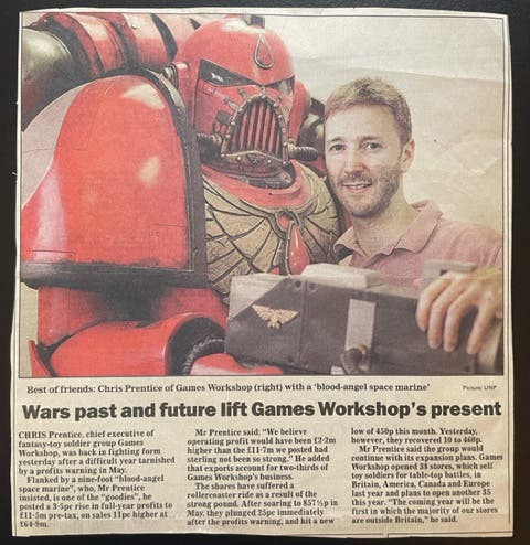 A newspaper clipping showing a life-sized Space Marine model and a masculine human. They appear to be the best of friends.