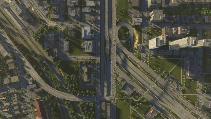 A top-down shot of a turnpike, a residential distrcit and some skyscrapes in Cities Skylines 2.