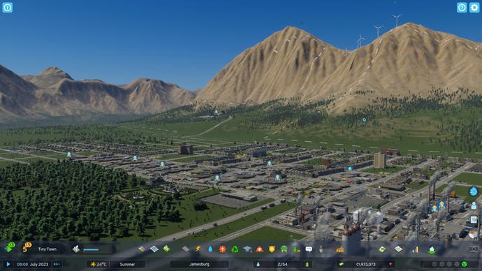 Bertie's Tiny Town in Cities Skylines 2. It's not that small to look at. The grid of housing and industry stretches out quite far. There's a small forest or wood in the foreground and then gigantic hills - mountains, even - in the background. I think Bertie's doing quite well. But then I would say that because I'm Bertie.