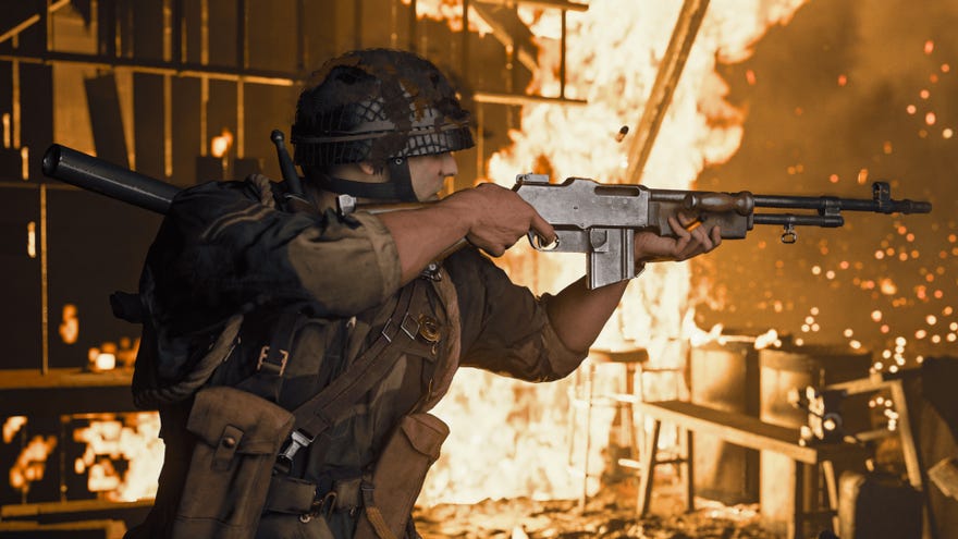A soldier aims their rifle offscreen while surrounded by flames in Call Of Duty: Vanguard.
