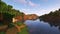 A screenshot of a river in Minecraft, with some trees on either side of the bank and a hill in the distance, taken using Complementary shaders.