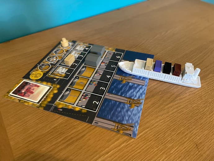 A board from the Container board game (Jumbo Edition), on a table and with a container ship miniature parked on top of it.