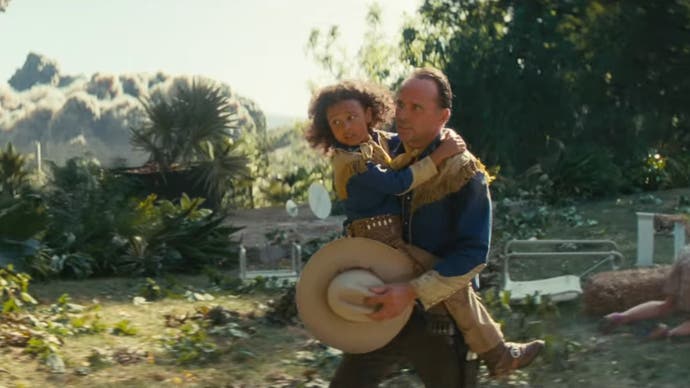 Walton Goggins como Cooper Howard en la serie de televisión Fallout de Amazon sosteniendo a un niño mientras huye de una explosión.