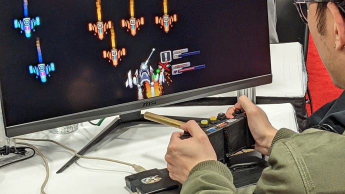 One player holds a custom controller that's shaped like a gun turret at GDC.