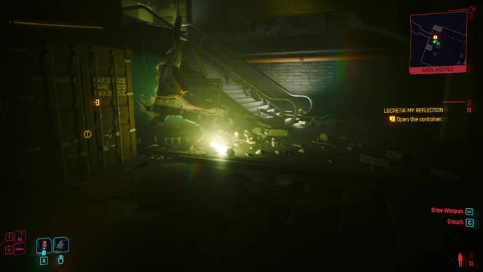 A shipping container under a rubble-covered staircase.