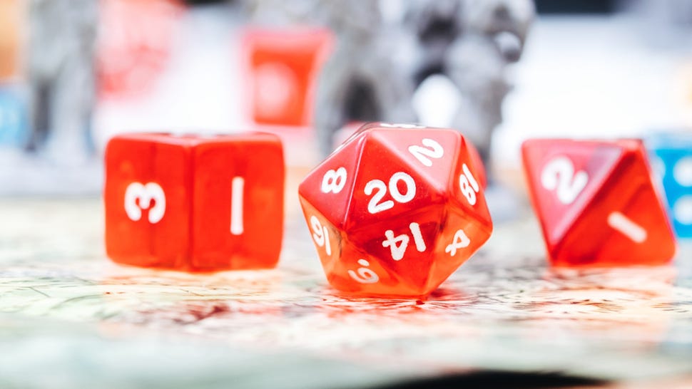 Red dice on a board with miniatures in the background