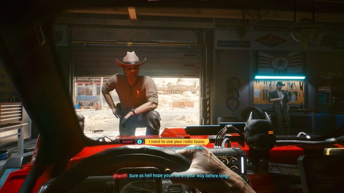 The player in Cyberpunk 2077 sits in the driver's seat of their car in a garage. A sheriff stands at the front of the car, with one foot on the bonnet.