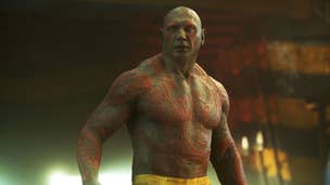Dave Bautista as Drax is stood shirtless in a prison, wearing only prison trousers.