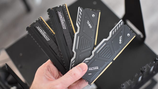 Some DDR4 and DDR5 RAM modules, fanned out and held in a hand.