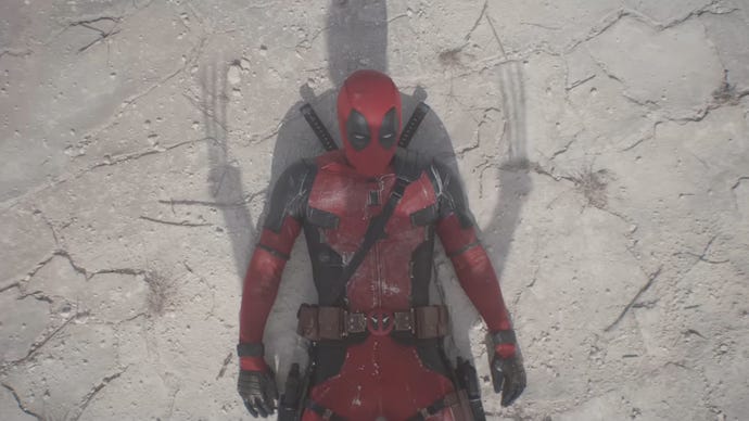 Deadpool is laying on the ground, looking up at Wolverine, who's shadow can be see over Deadpool.