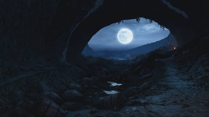 Screenshot of Dear Esther showing a point of view from inside a cave. Through the mouth of the cave you can see a night sky lit up by a bright full moon.