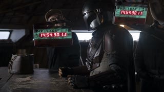 Set Still of The Mandalorian standing at a bar, directors are behind him holding clapperboards