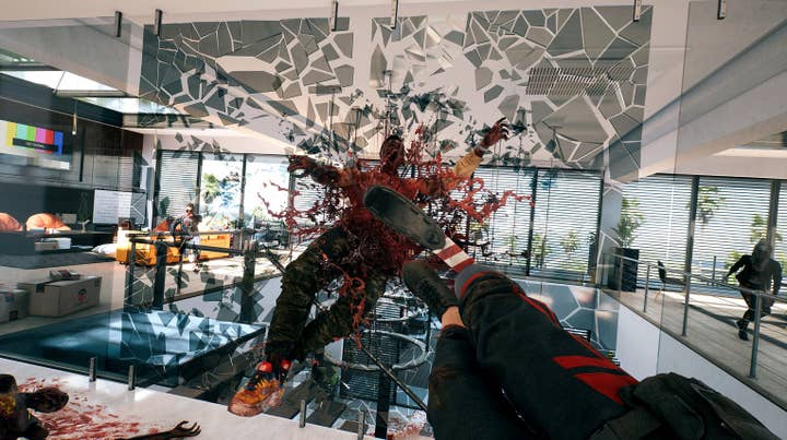 Dead Island 2 screen showing first-person view of a woman with a prosthetic leg dropkicking a zombie through a suspended plate of glass in an office
