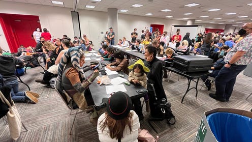 Photograph of a room filled with people drawing