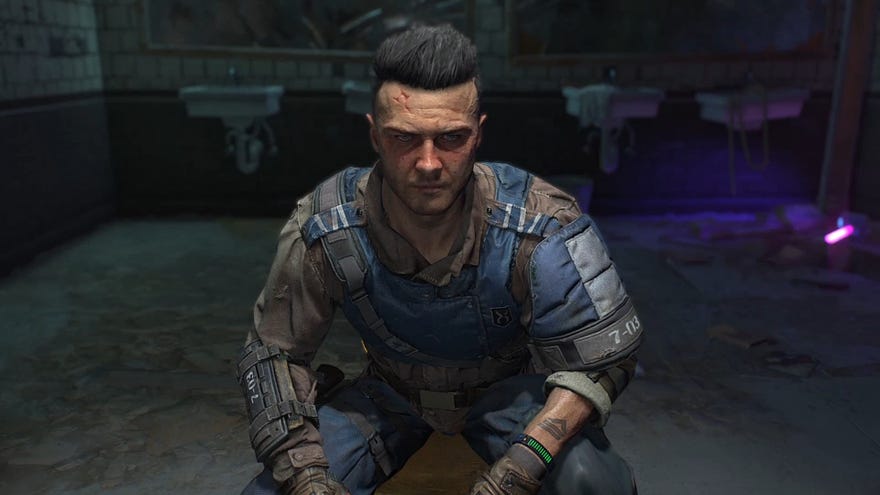 A close-up of Aitor in Dying Light 2, crouching in a small unlit bathroom in front of the player.