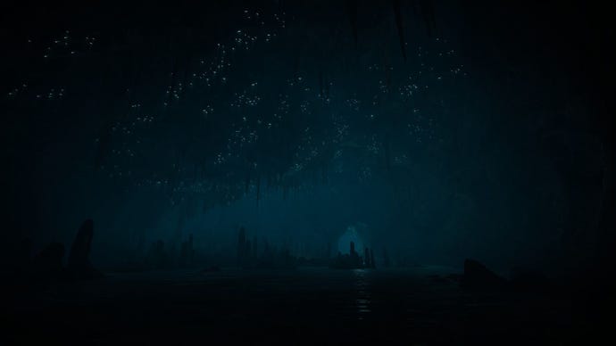 A screen shot of the deep, dark cave in Eastshade, stalactites and stalagmites dimly visible and tiny pinpricks of light on the ceiling that look like stars