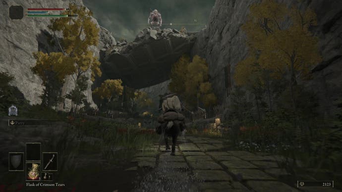 An armoured and cloaked character riding a horse under a makeshift bridge, with a troll standing on top of the bridge.