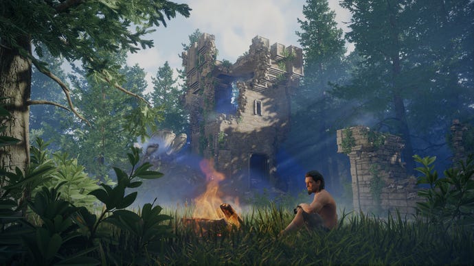A player in Enshrouded sits in the grass by a campfire, just outside some ruins.
