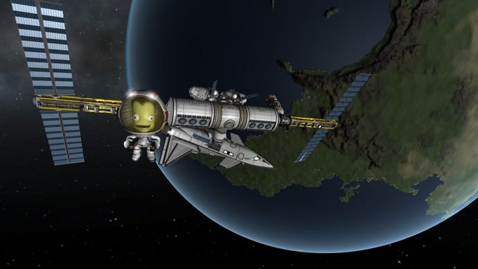 A green Kerbal smiles in space in front of a satellite station in the original Kerbal Space Program