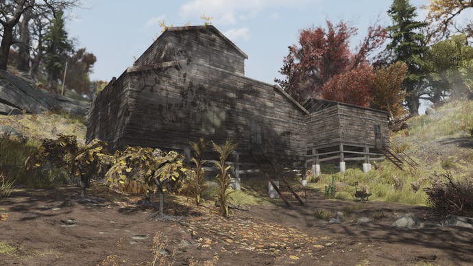 Fallout 76 State of the Game - a large, brown, wood-clad cabin with no windows, looking ominous amongst some trees